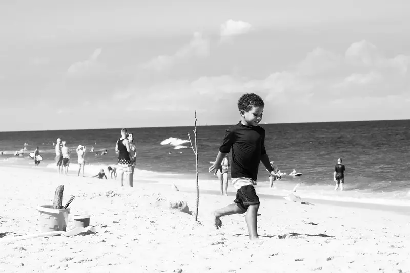 Boy running on beach, monochrome